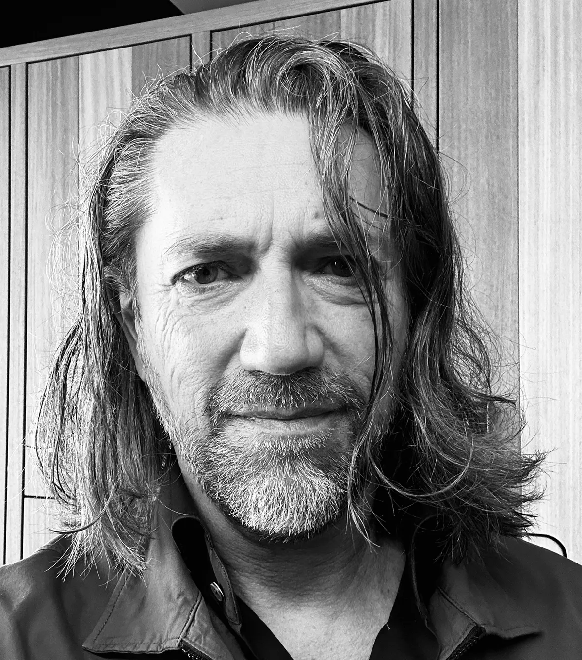Black and white portrait of Robert Daniel — long hair, beard, slight smile.